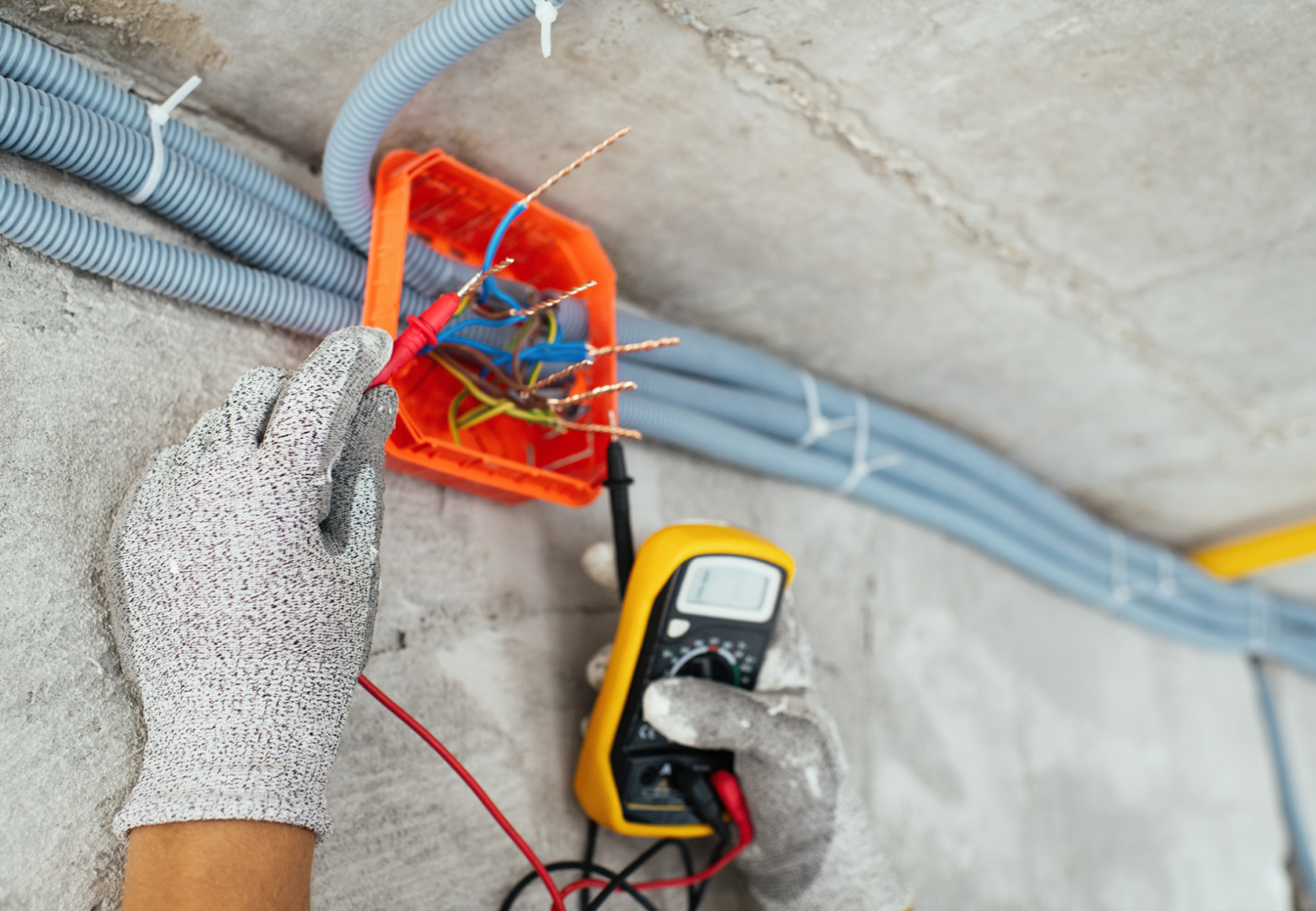 Electrician using multimeter to test wires.
