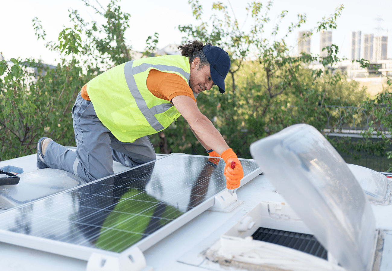 Worker installing solar panels on roof.