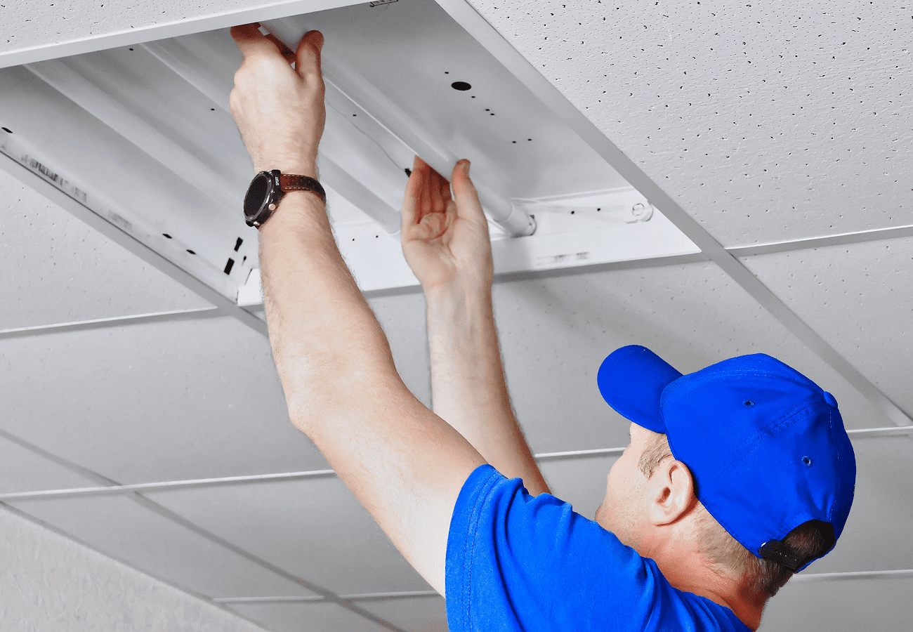 Person installing ceiling light fixture.