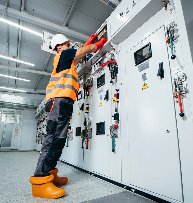 Technician working on electrical control panel.