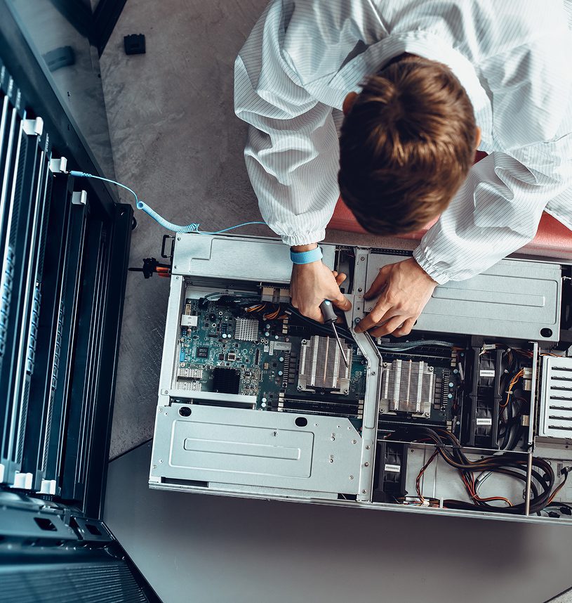 Technician repairing computer server in lab coat.