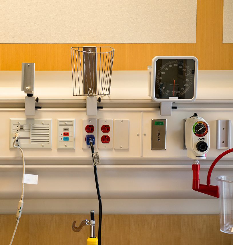 Hospital room wall with medical equipment.