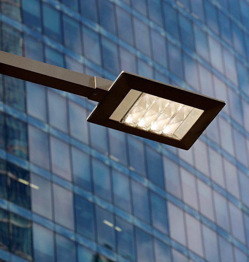 Modern streetlight against glass building background.