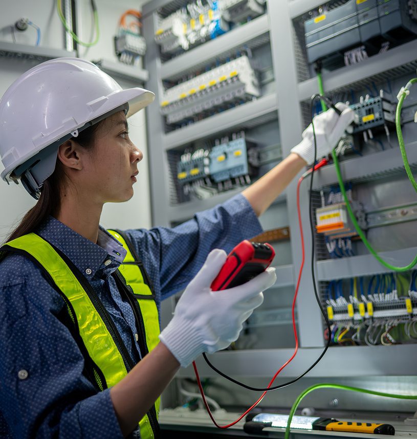 Electrician inspecting electrical panel with multimeter.